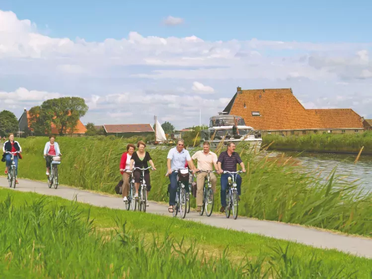 Groep fietsers in Friesland langs het water
