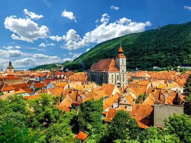 Brasov stadsgezicht met zwarte kathedraal en bergen in Roemenië