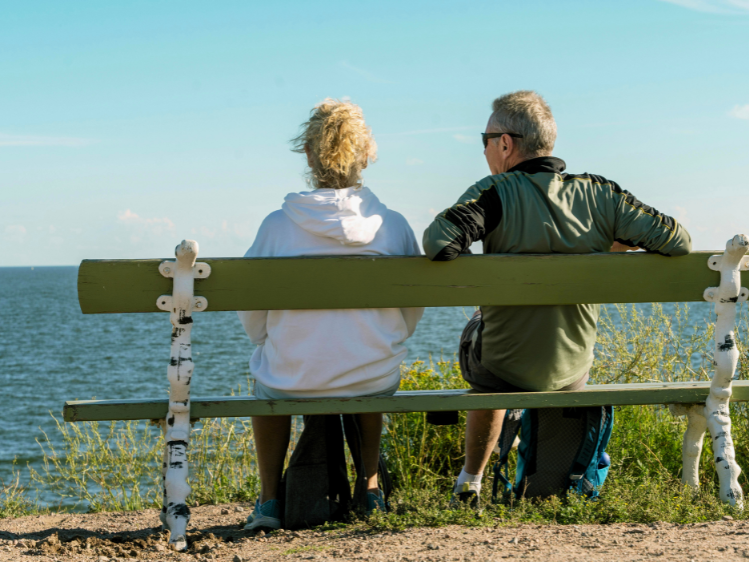 Wandelaars op een bankje bij zee.webp